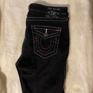 True religion boot cut black jeans with pink stitching.